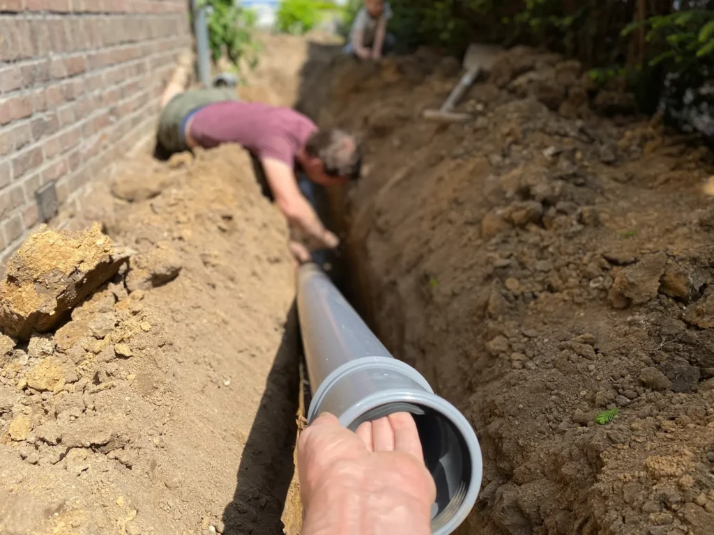 Professional plumbers installing a new underground sewer line as part of sewer services in Kansas City, MO, ensuring proper drainage and functionality.