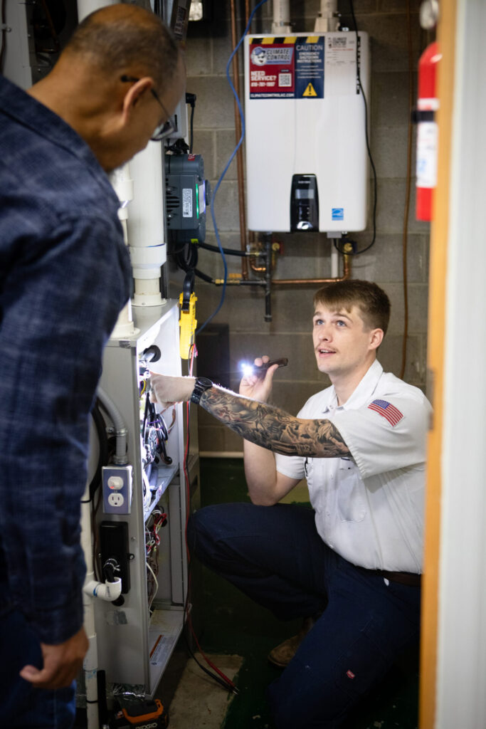 A man is focused on repairing a gas furnace