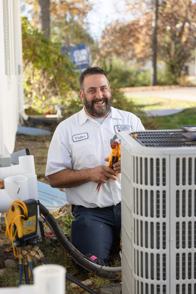 A technician holding a tool, diligently working on an air conditioning unit