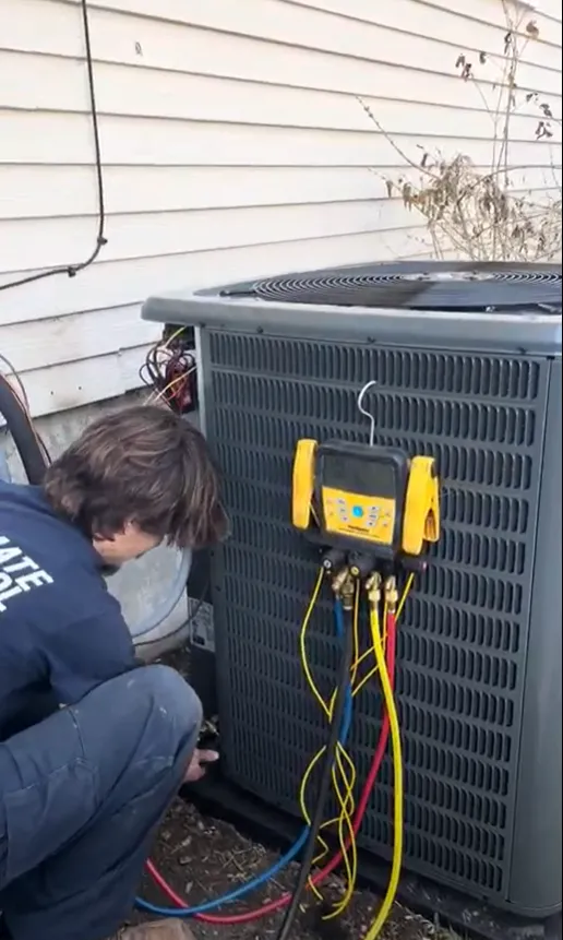 A man diligently works on an air conditioning unit